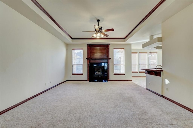 unfurnished living room featuring crown molding, a fireplace, light carpet, and ceiling fan with notable chandelier