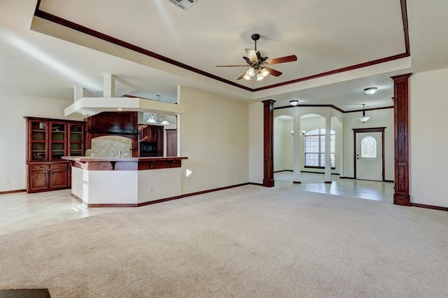 unfurnished living room with light carpet, decorative columns, ceiling fan, and ornamental molding