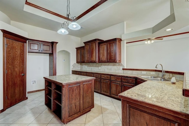 kitchen featuring decorative backsplash, sink, light tile patterned floors, a center island, and hanging light fixtures