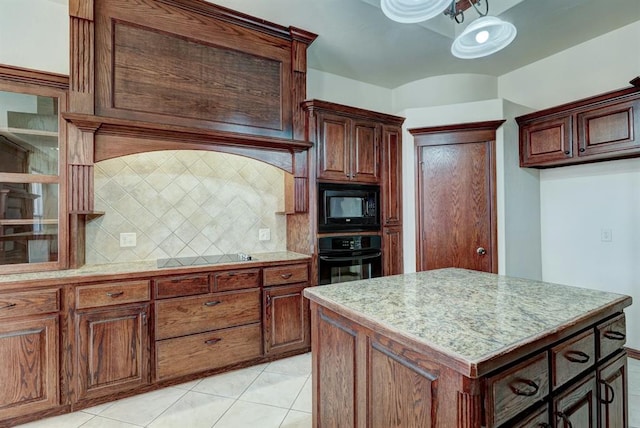 kitchen with tasteful backsplash, light tile patterned flooring, a kitchen island, and black appliances