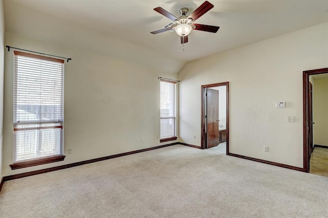 unfurnished bedroom with ceiling fan, light colored carpet, connected bathroom, and vaulted ceiling