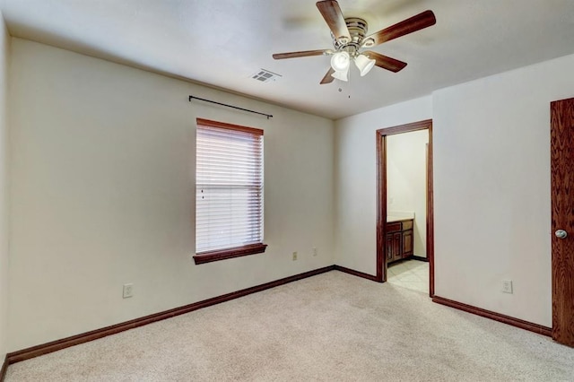 empty room featuring ceiling fan and light carpet