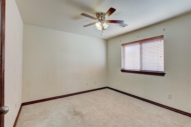 carpeted spare room featuring ceiling fan