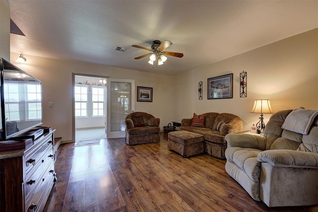 living room featuring ceiling fan and dark hardwood / wood-style floors