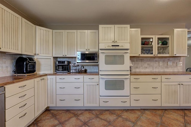 kitchen with cream cabinetry, stainless steel microwave, and double oven