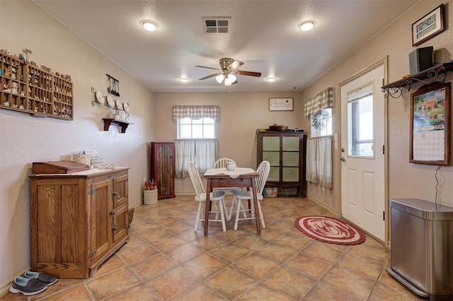 tiled dining area with ceiling fan