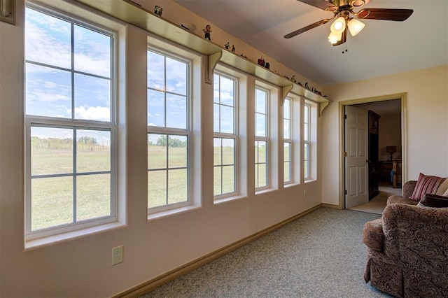 interior space featuring carpet flooring, ceiling fan, and a healthy amount of sunlight