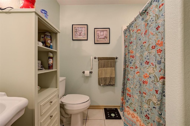 bathroom with tile patterned flooring, toilet, and curtained shower