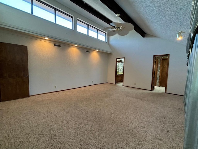 carpeted spare room featuring ceiling fan, beamed ceiling, high vaulted ceiling, and a textured ceiling