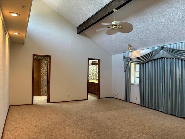 carpeted spare room featuring vaulted ceiling with beams, ceiling fan, and a textured ceiling