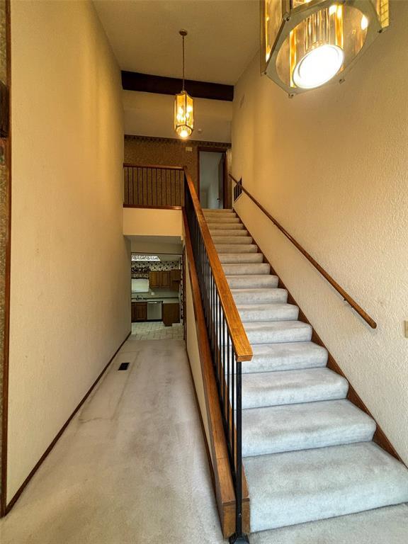 stairway featuring a chandelier and carpet floors