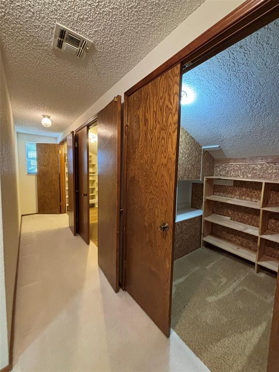 corridor featuring carpet floors and a textured ceiling