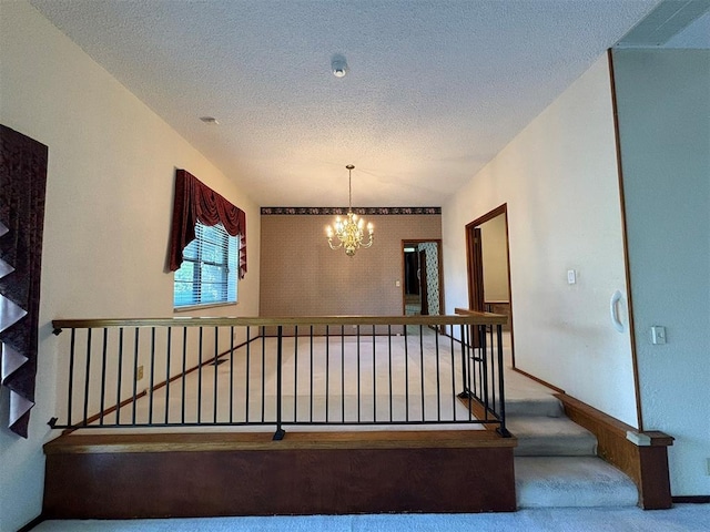 stairs featuring vaulted ceiling, carpet floors, a chandelier, and a textured ceiling