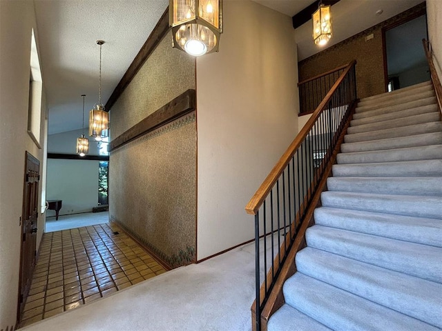 stairway with tile patterned floors, high vaulted ceiling, and an inviting chandelier