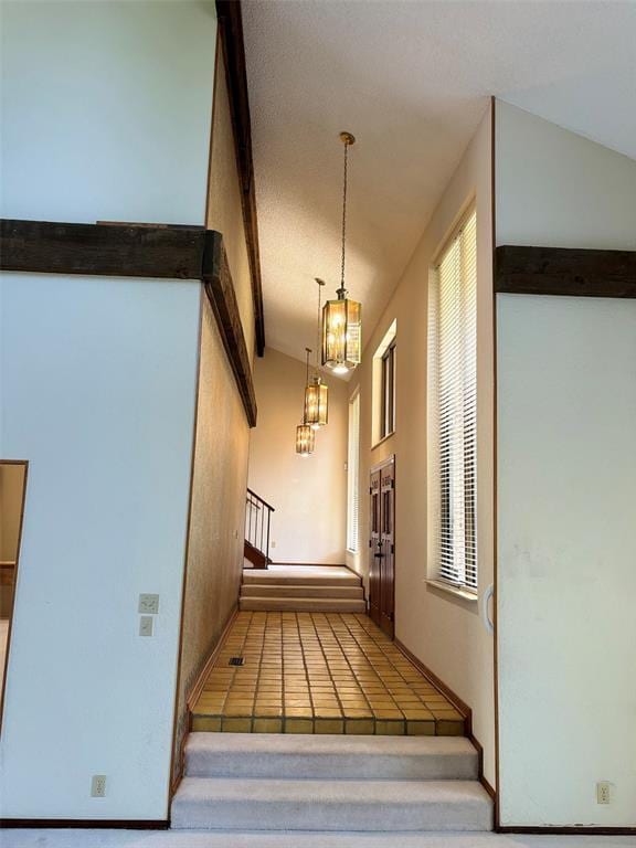 stairway featuring lofted ceiling with beams and a notable chandelier