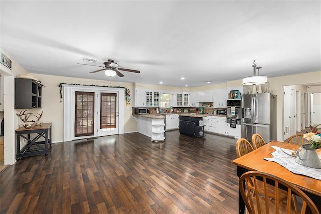 kitchen with dark hardwood / wood-style floors, ceiling fan, appliances with stainless steel finishes, decorative light fixtures, and white cabinetry