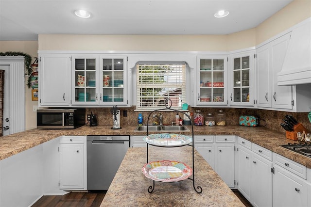 kitchen with backsplash, dark wood-type flooring, sink, white cabinetry, and stainless steel appliances