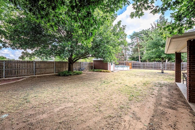 view of yard with a fenced in pool and a storage shed