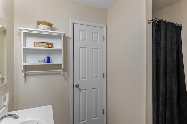 bathroom with curtained shower and sink