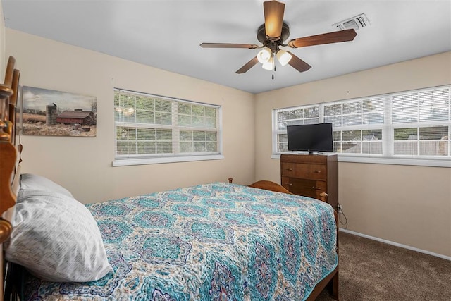 carpeted bedroom featuring ceiling fan and multiple windows