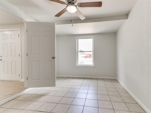 empty room with ceiling fan and light tile patterned floors