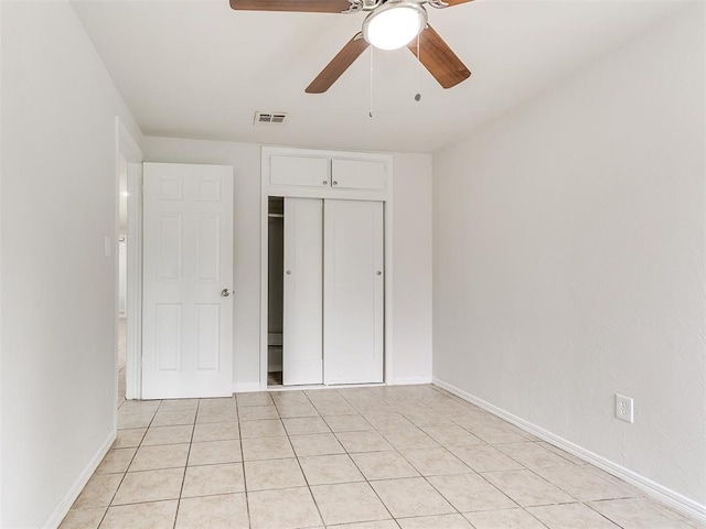 unfurnished bedroom featuring ceiling fan, a closet, and light tile patterned floors