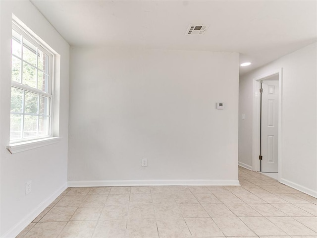 spare room with light tile patterned flooring and a healthy amount of sunlight