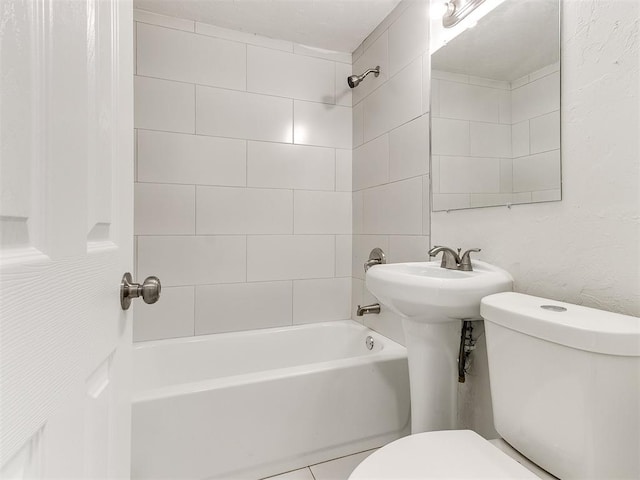 bathroom with tiled shower / bath and toilet