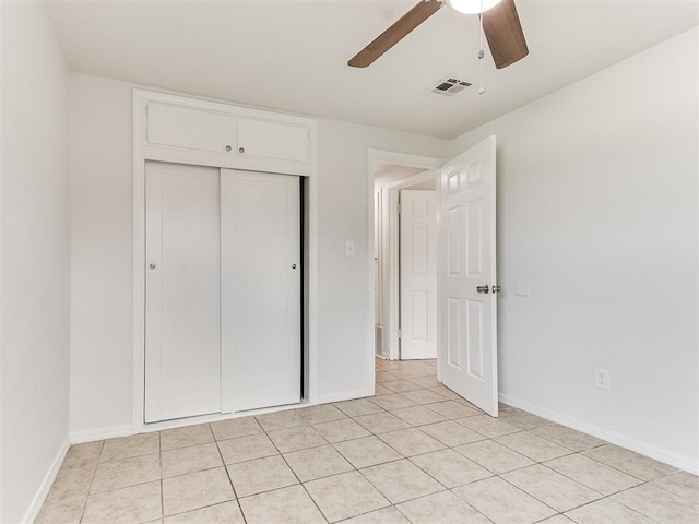 unfurnished bedroom with ceiling fan, a closet, and light tile patterned floors