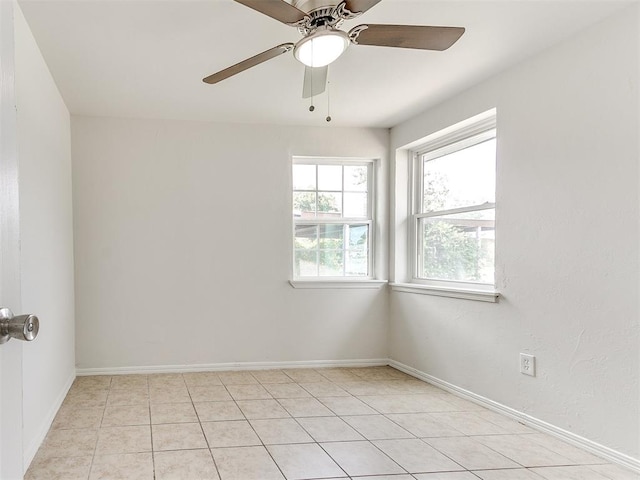 spare room with ceiling fan and light tile patterned floors