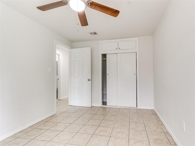 unfurnished bedroom with ceiling fan, light tile patterned floors, and a closet