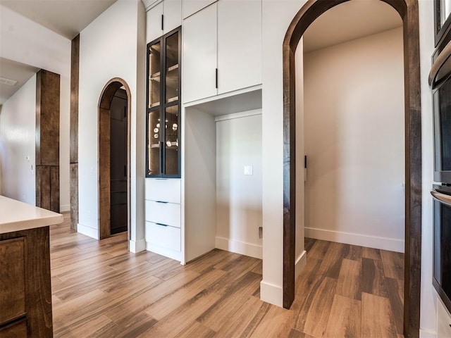 kitchen with hardwood / wood-style flooring and white cabinetry