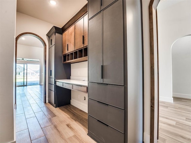 kitchen with built in desk and light hardwood / wood-style flooring