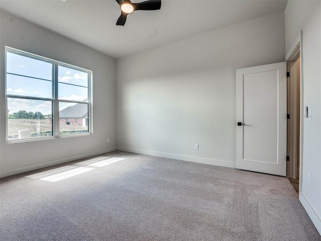 carpeted spare room featuring ceiling fan