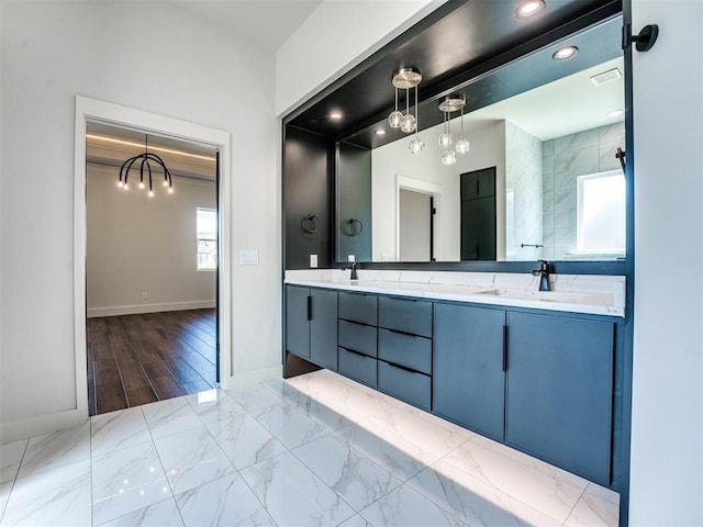 bathroom with a wealth of natural light, vanity, wood-type flooring, and a notable chandelier