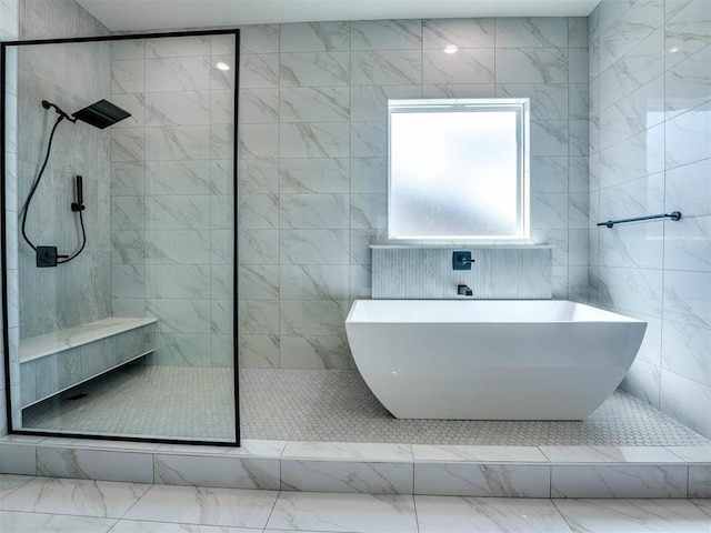 bathroom featuring separate shower and tub and tile walls