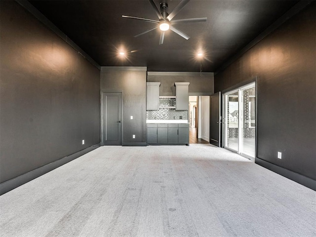 unfurnished living room featuring light carpet, ceiling fan, and crown molding