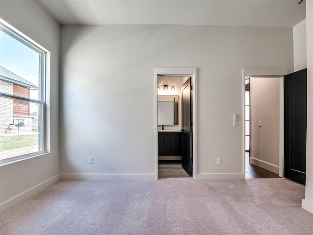 unfurnished bedroom featuring carpet flooring and connected bathroom