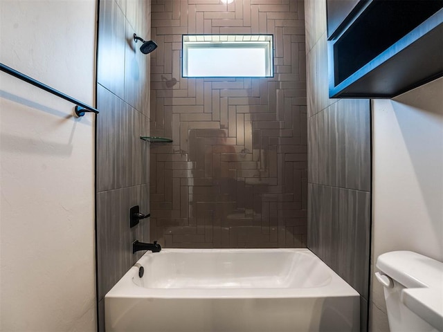 bathroom with tiled shower / bath combo and toilet