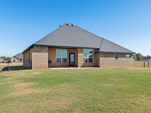 rear view of house with a yard and a patio