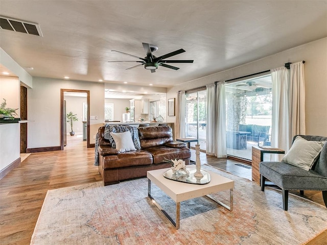 living room with ceiling fan and light wood-type flooring