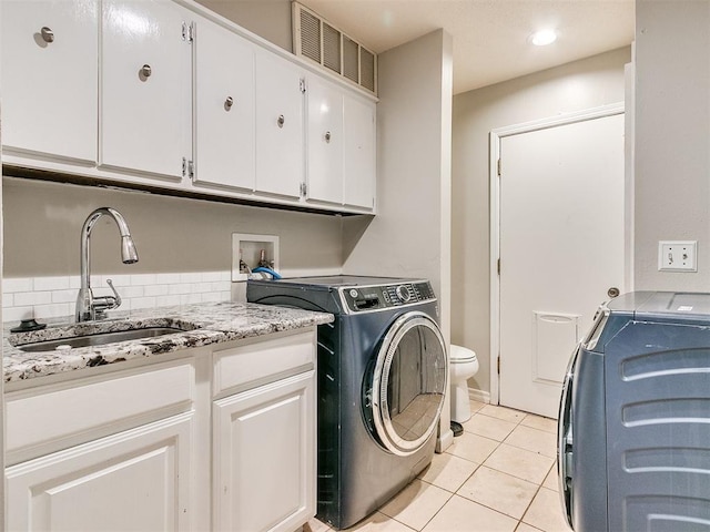 clothes washing area with independent washer and dryer, light tile patterned floors, and sink