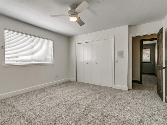 unfurnished bedroom featuring ceiling fan, light carpet, and a closet