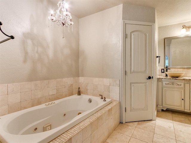 bathroom with tile patterned floors, tiled tub, vanity, and a chandelier