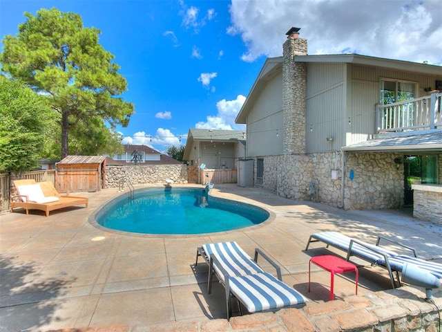 view of pool with a patio area and a diving board