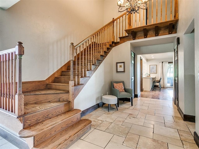 stairway with a chandelier and a high ceiling