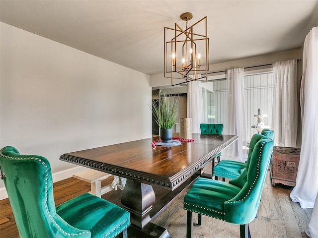 dining room with hardwood / wood-style floors and a notable chandelier