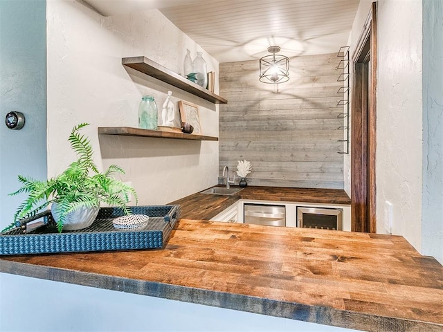 interior space with wine cooler, sink, stainless steel dishwasher, and wood counters