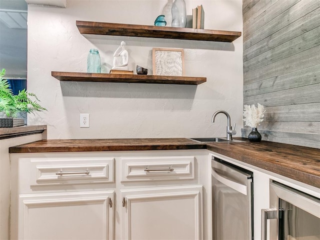 kitchen featuring white cabinetry, sink, and beverage cooler