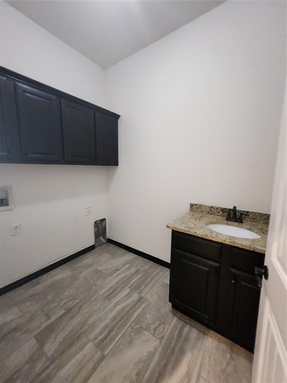 clothes washing area with sink, cabinets, and washer hookup